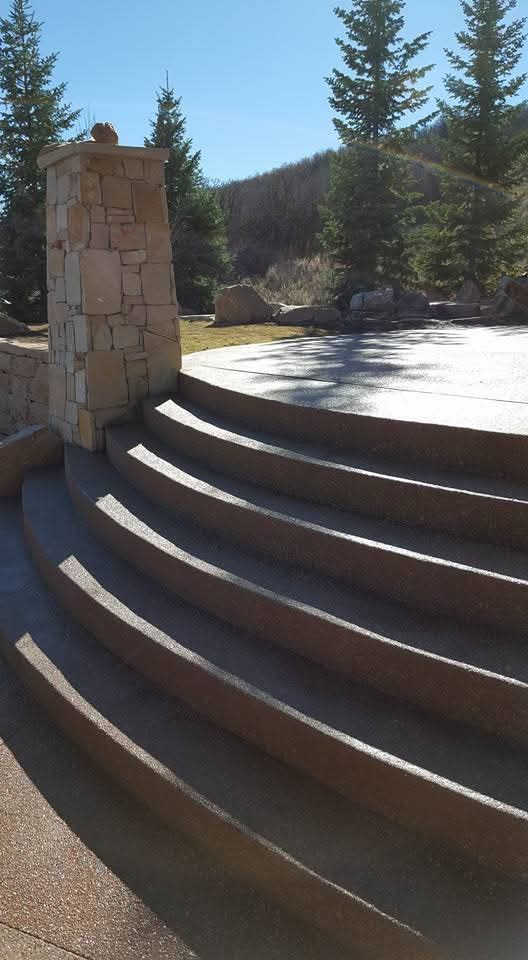 A set of curved stairs with a stone pillar in the background