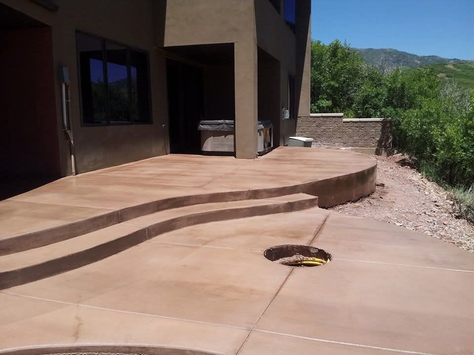 A concrete patio with steps leading up to a house