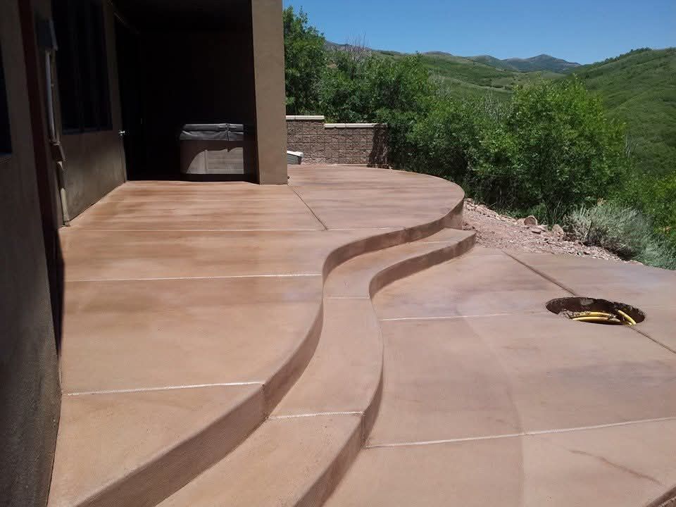 A curved concrete patio with stairs and a fire pit