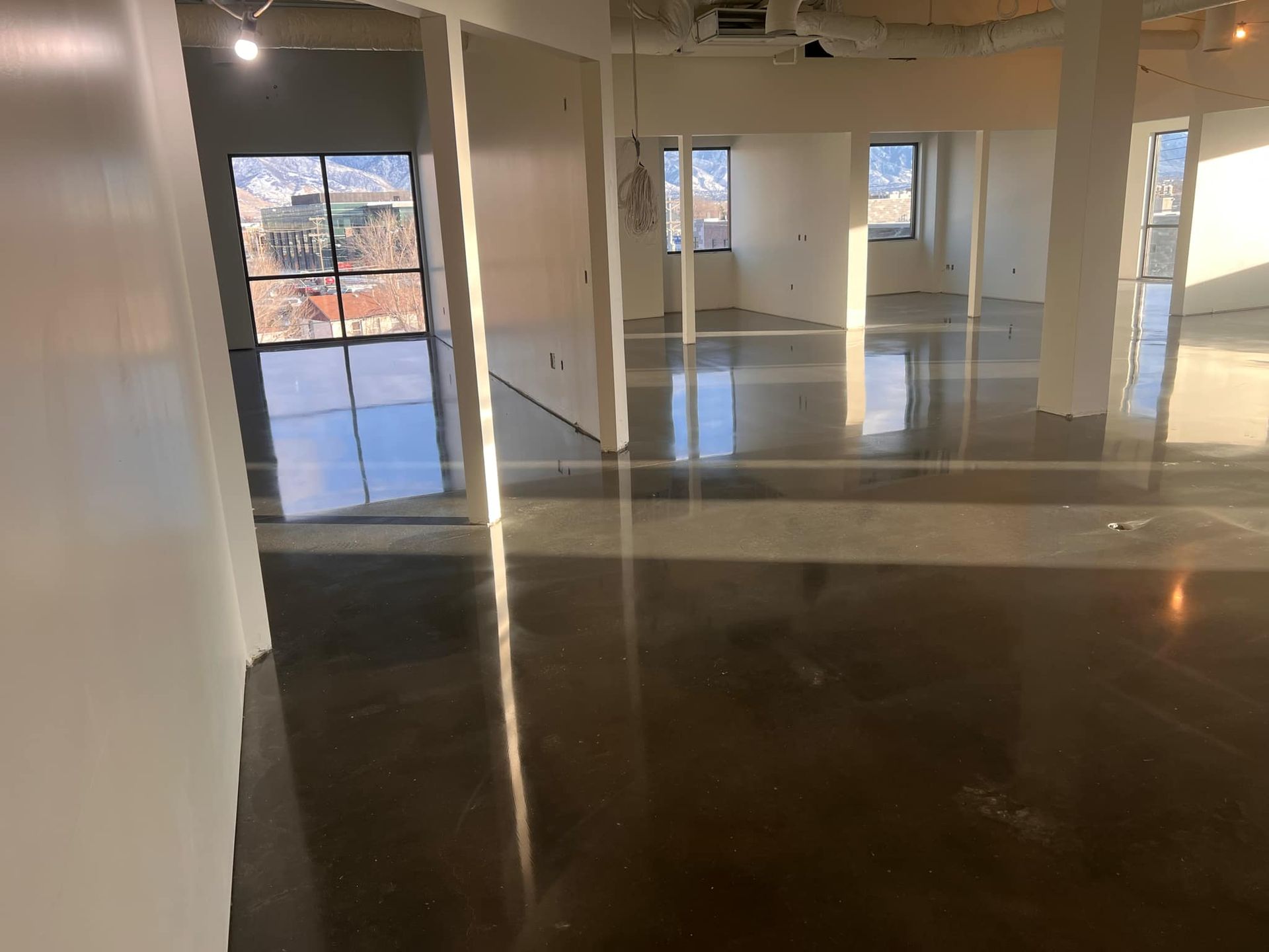 A large empty room with a concrete floor and a lot of windows.