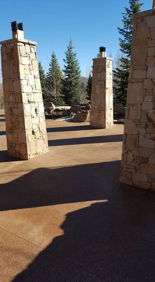 A row of stone pillars with trees in the background