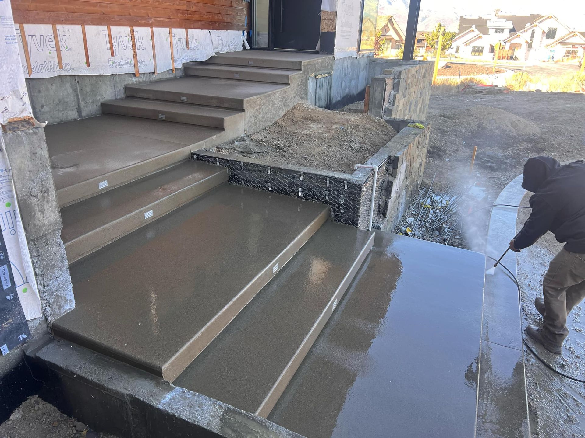 A man is cleaning concrete steps with a pressure washer.