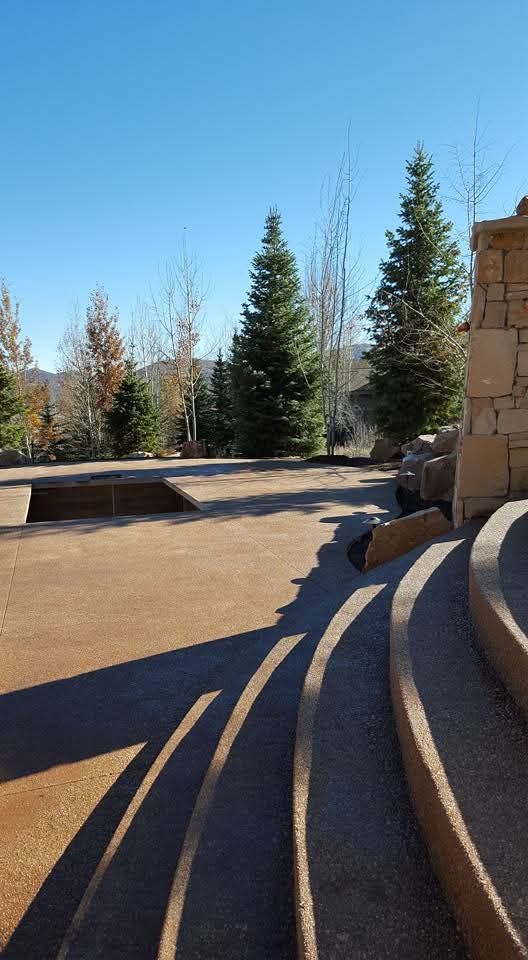 A staircase leading up to a stone wall with trees in the background.