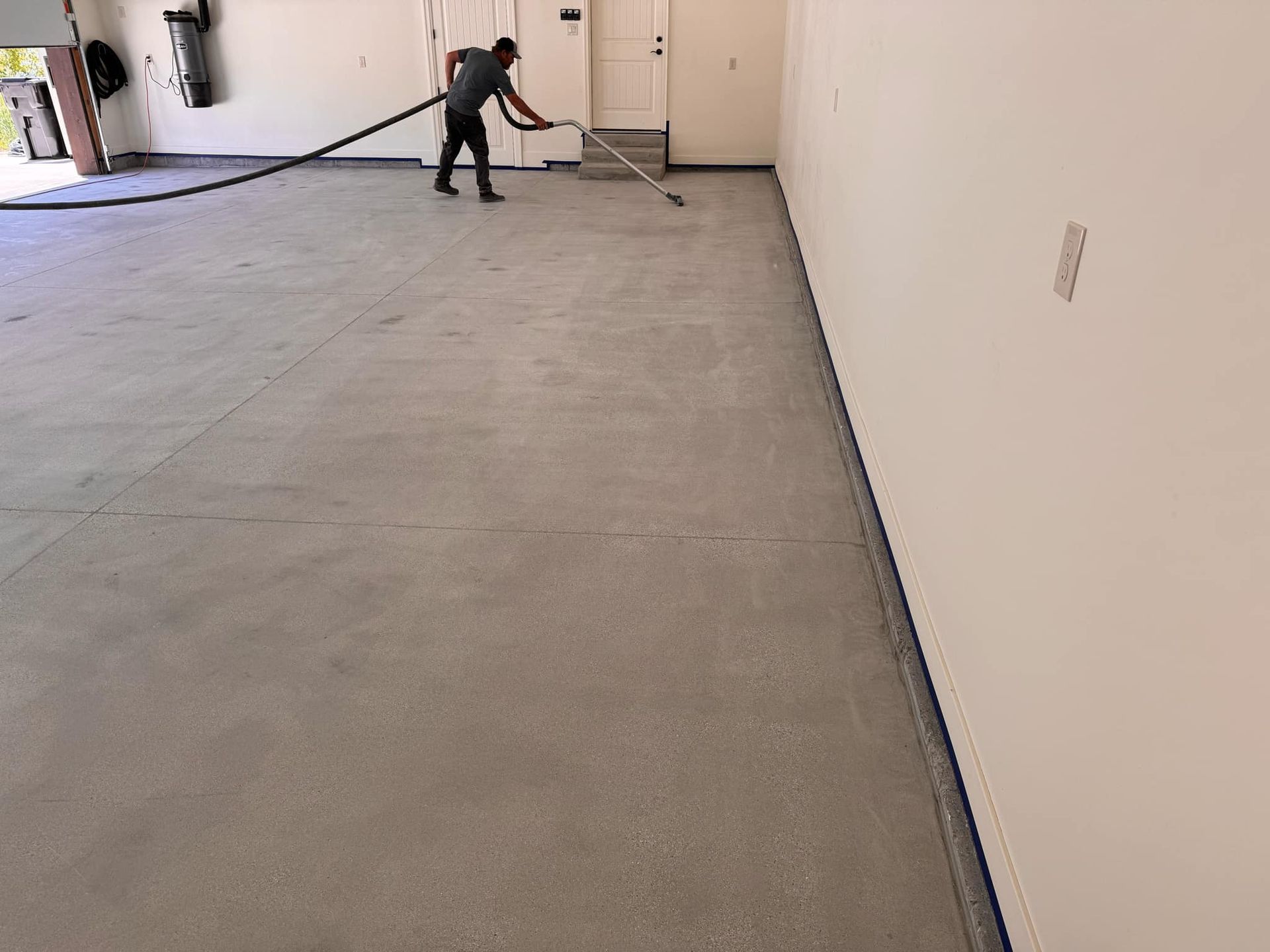 A man is sweeping the floor of a garage with a broom.