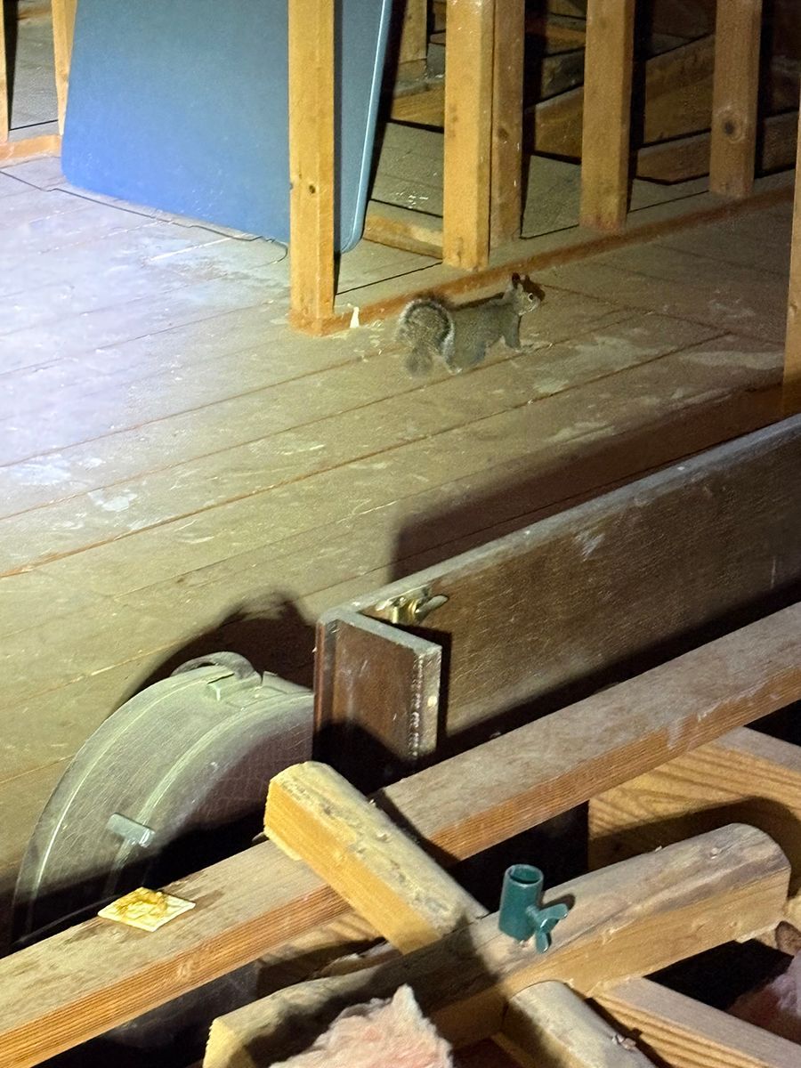 Close-up of a wooden railroad wheel and beam on a dusty floor indoors