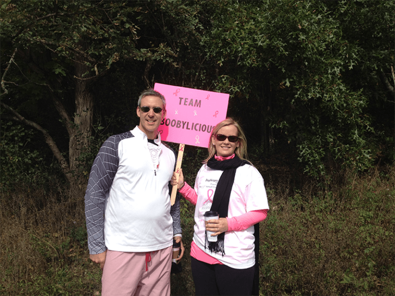 A man and woman holding a sign that says team