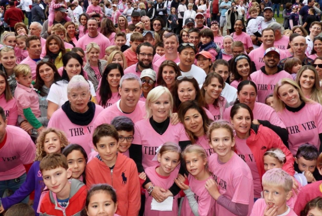 A large group of people wearing pink shirts that say thank you