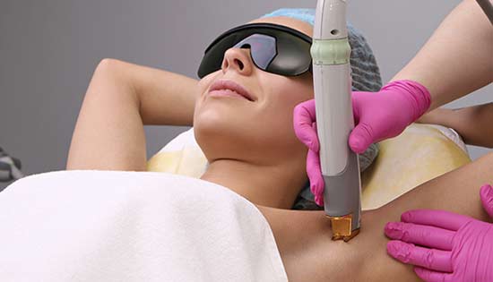 A woman is getting a laser hair removal treatment on her armpit.