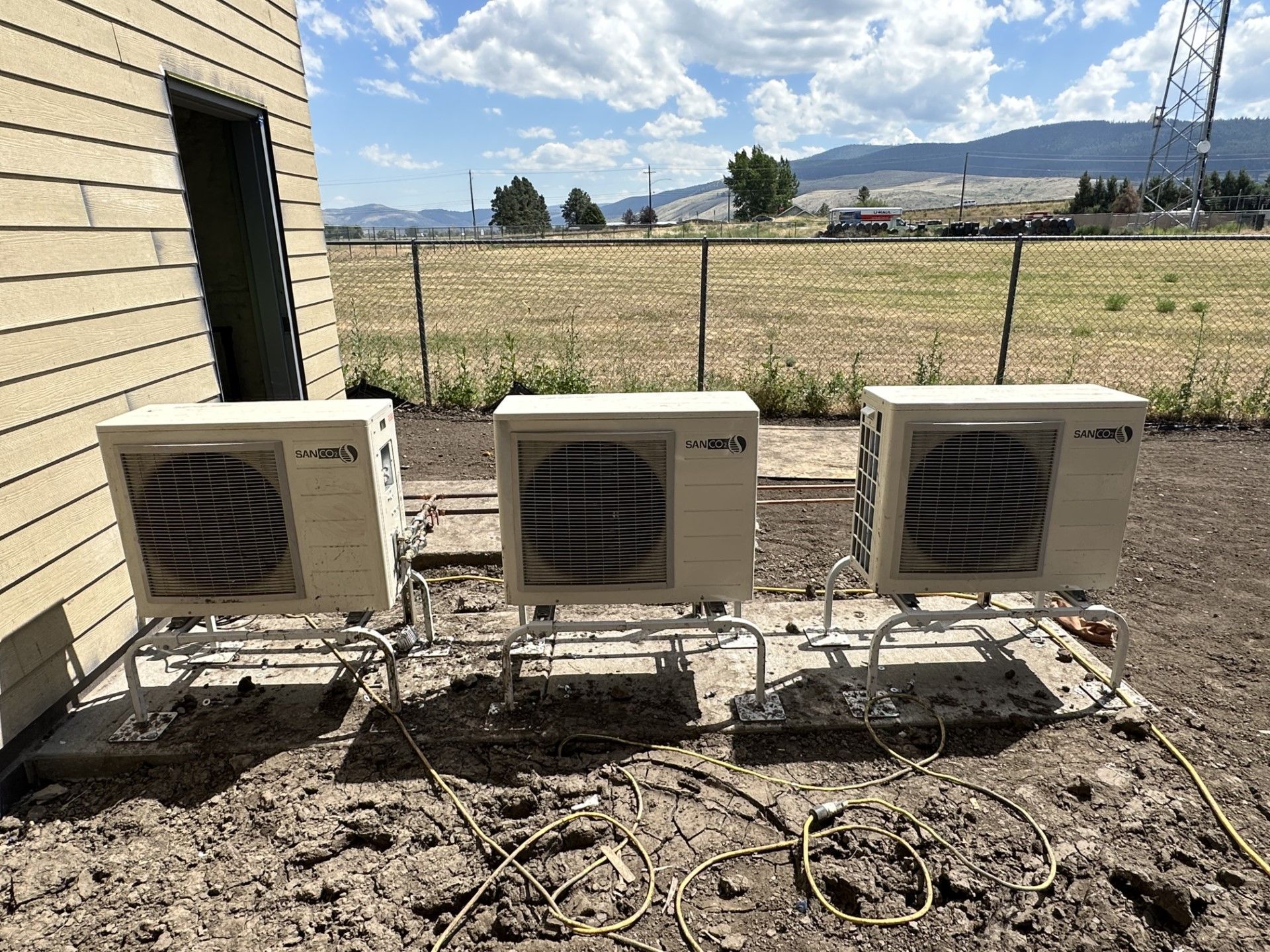 Three air conditioners are sitting outside of a building