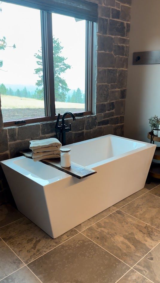 A bathtub is sitting in a bathroom next to a window