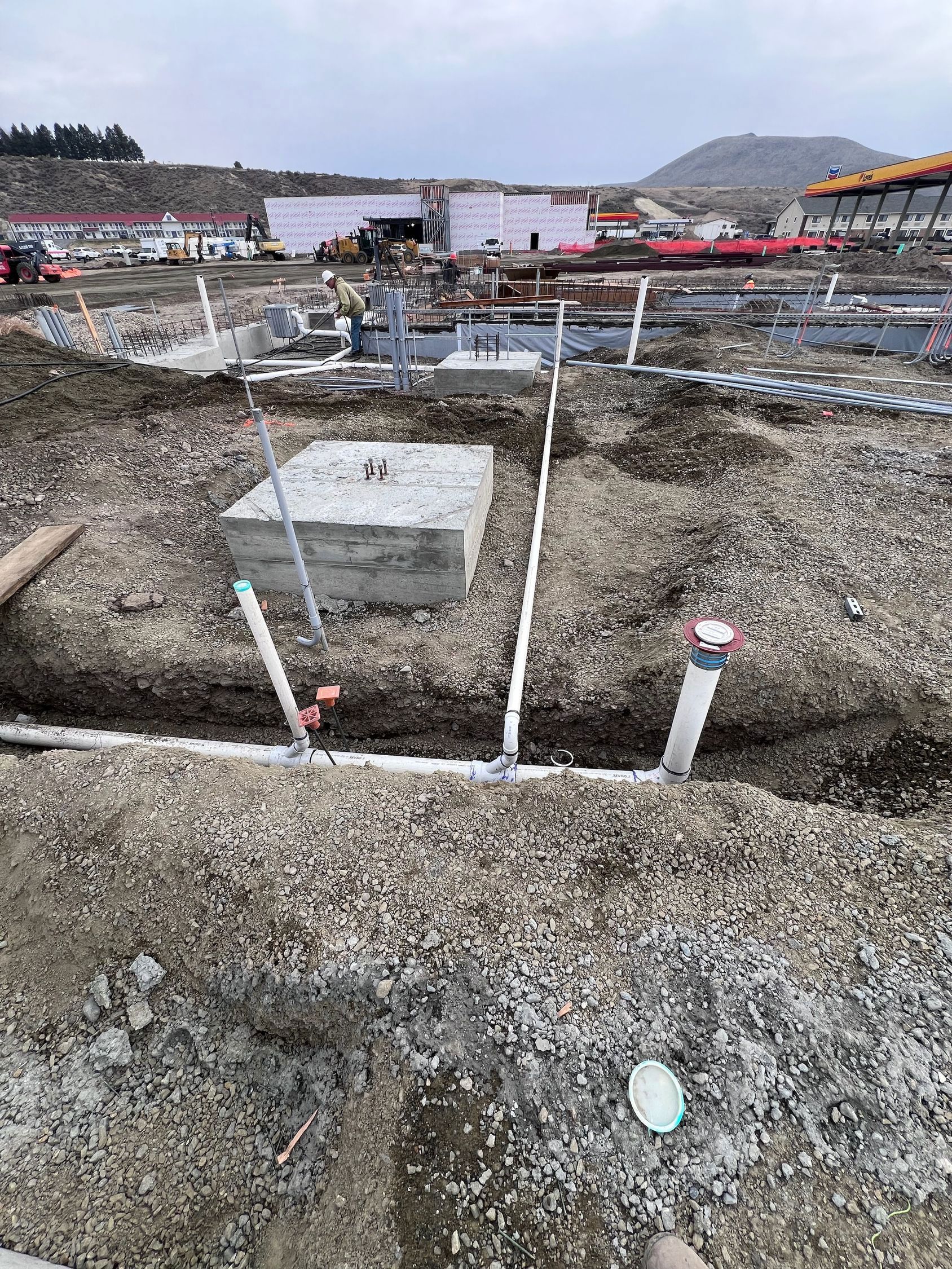 A construction site with a lot of pipes in the ground.