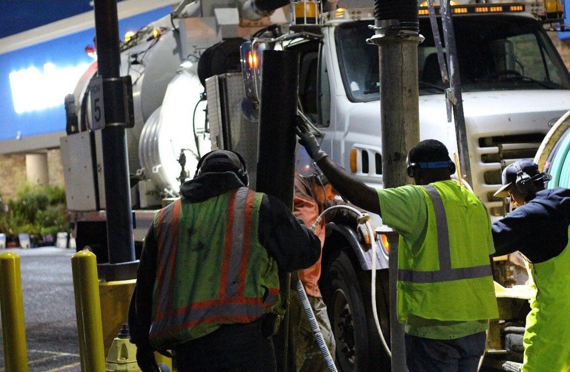 A group of construction workers standing in front of a truck