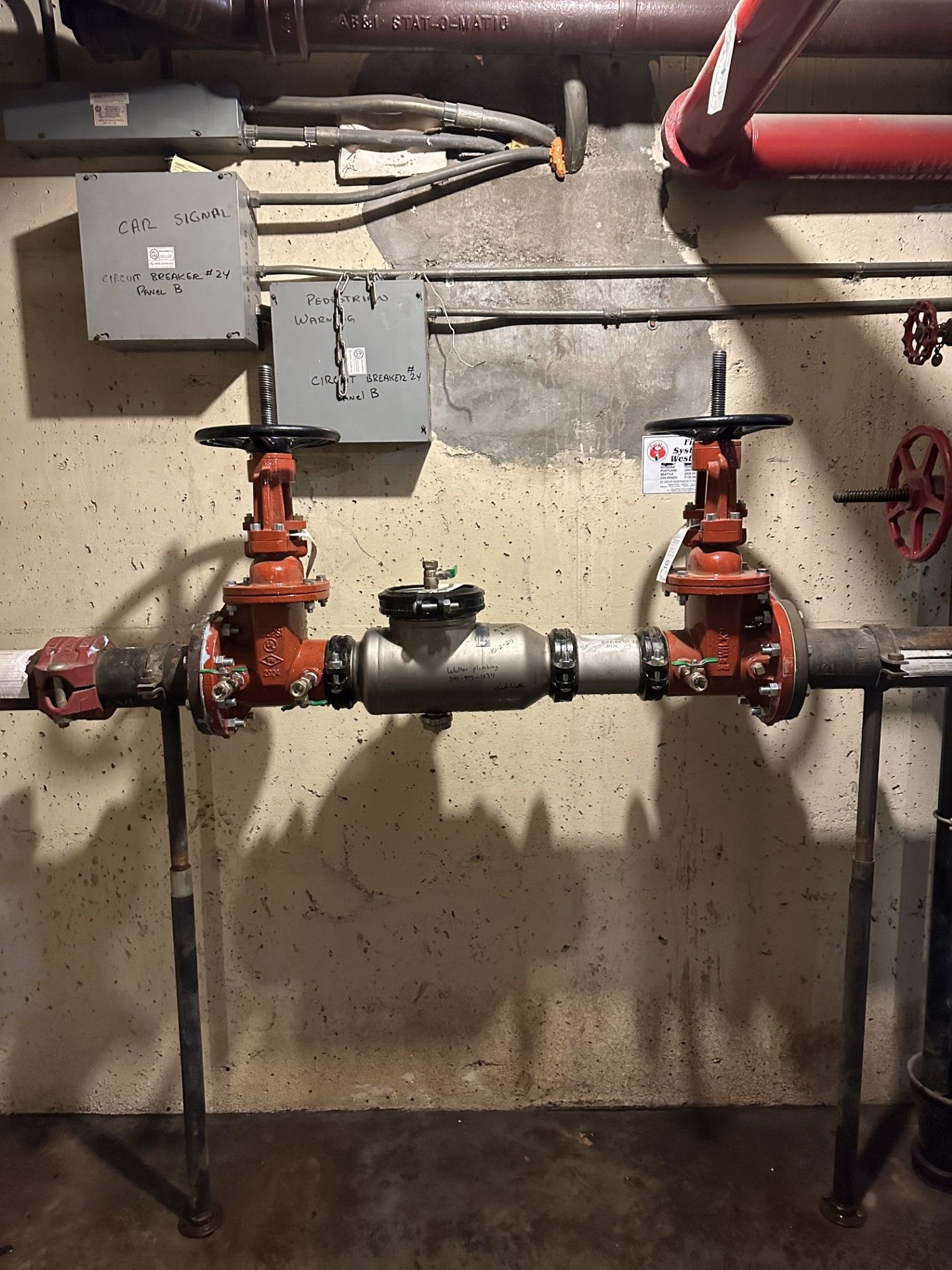 A room with a lot of pipes and valves on the wall.