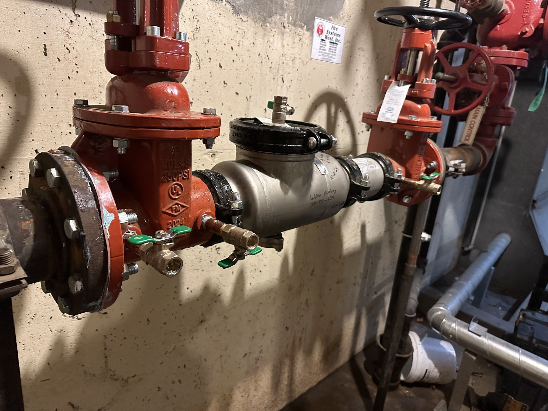 A room with a lot of pipes and valves on the wall.