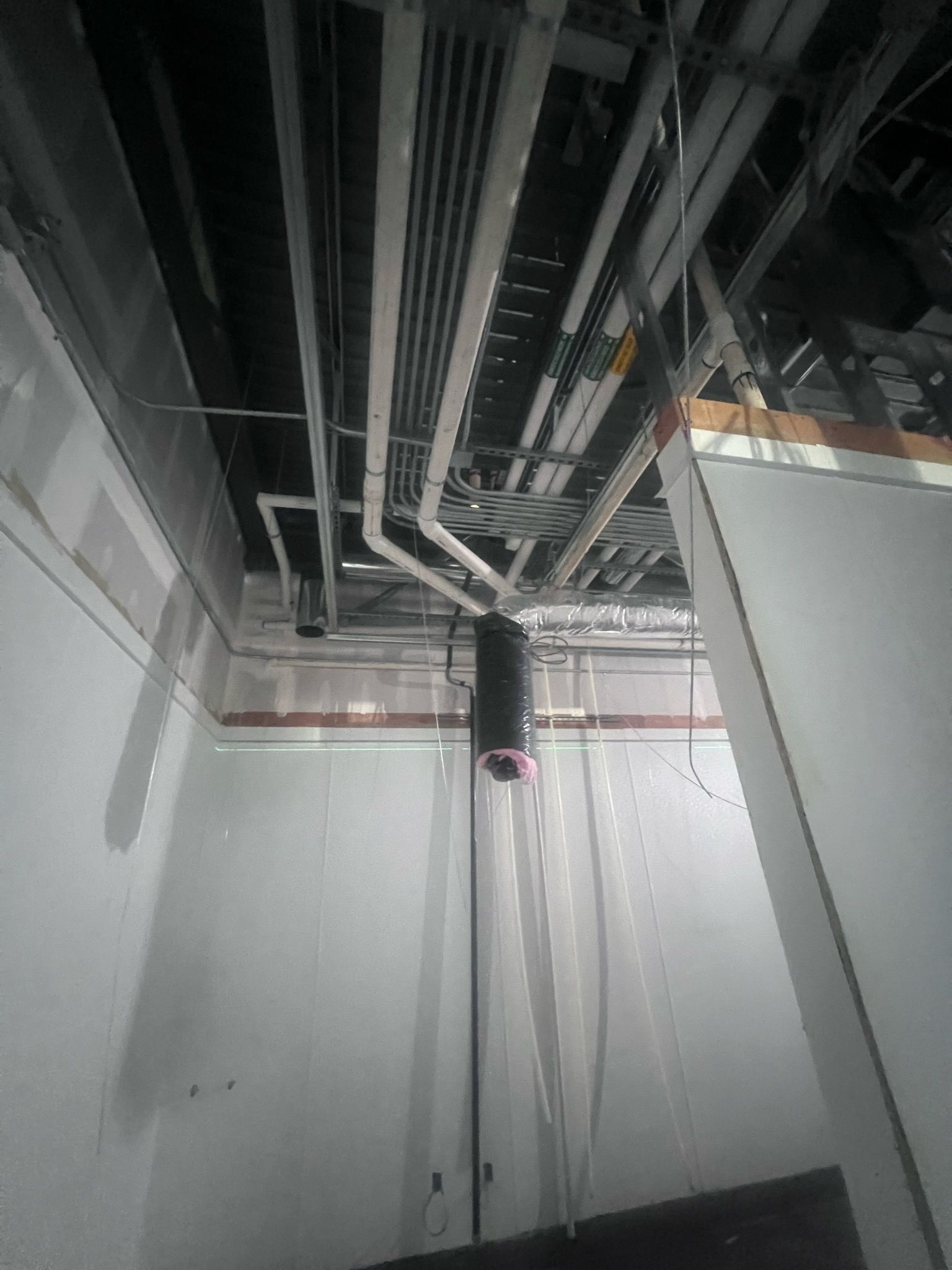 A room with a lot of pipes hanging from the ceiling