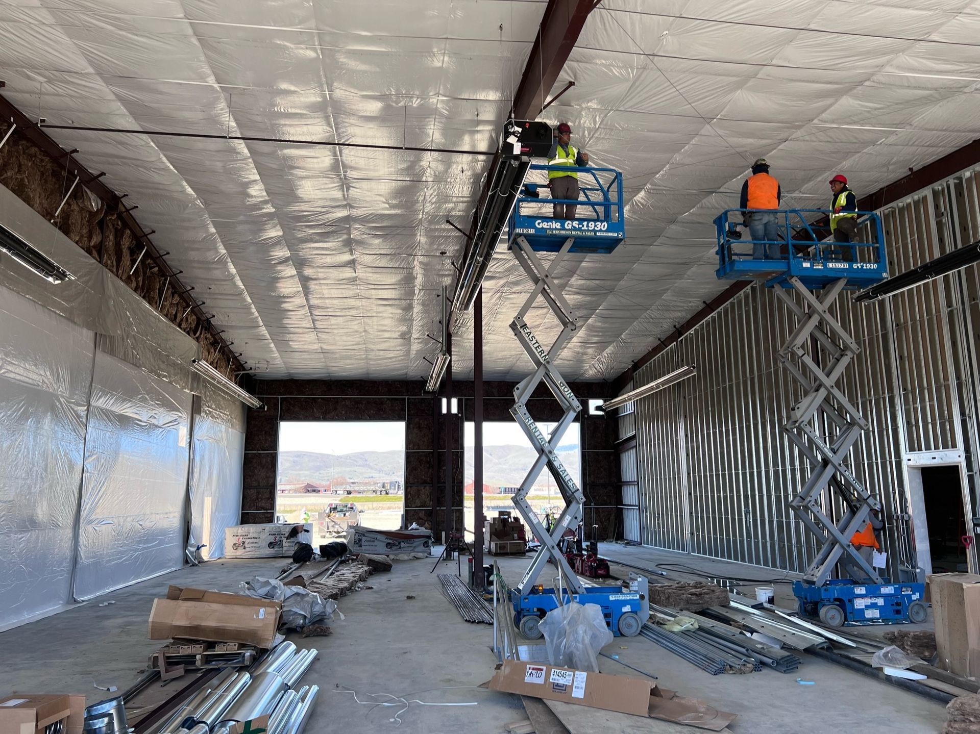 A group of workers are working on the ceiling of a building