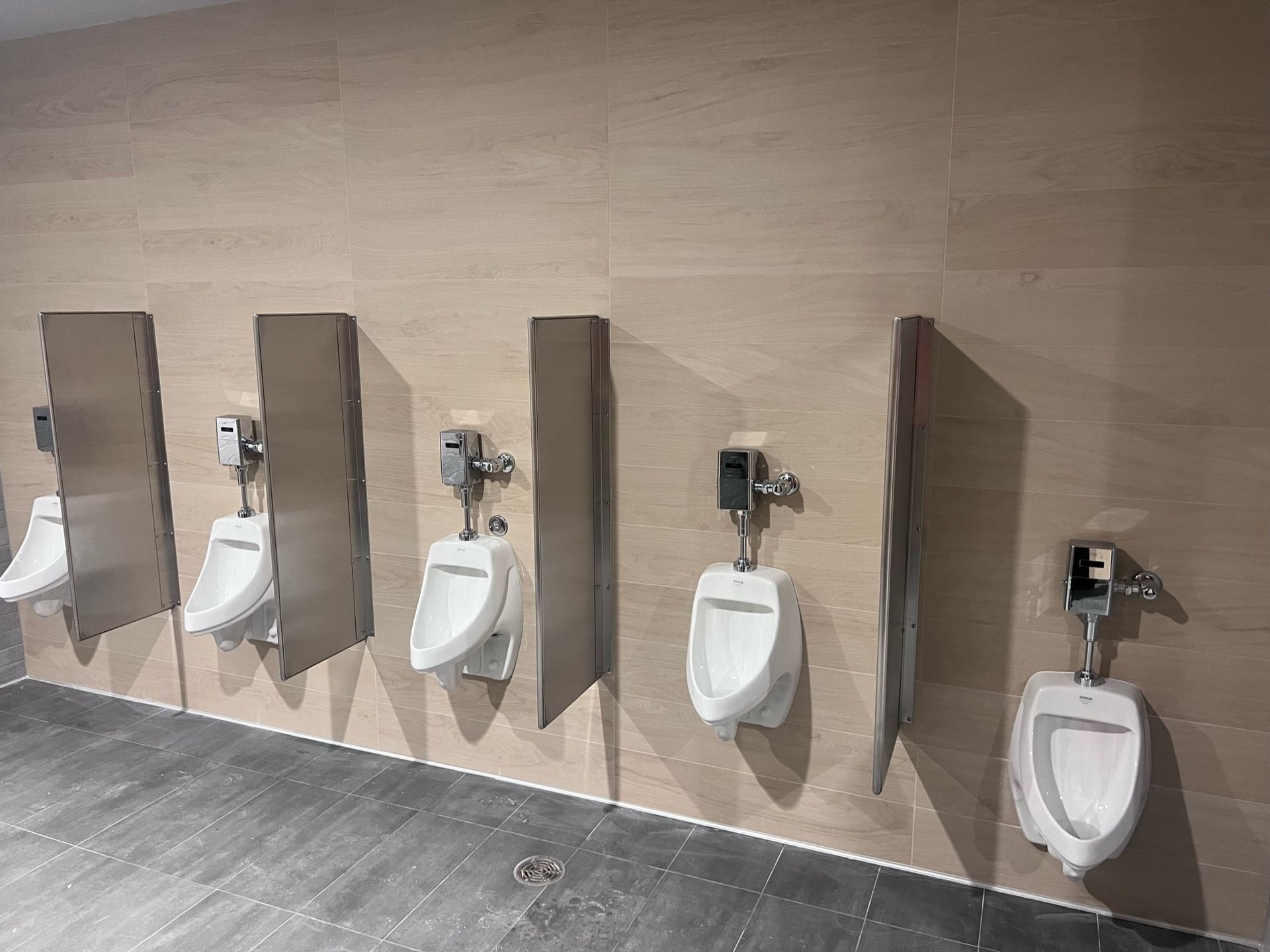A row of urinals are lined up in a public restroom
