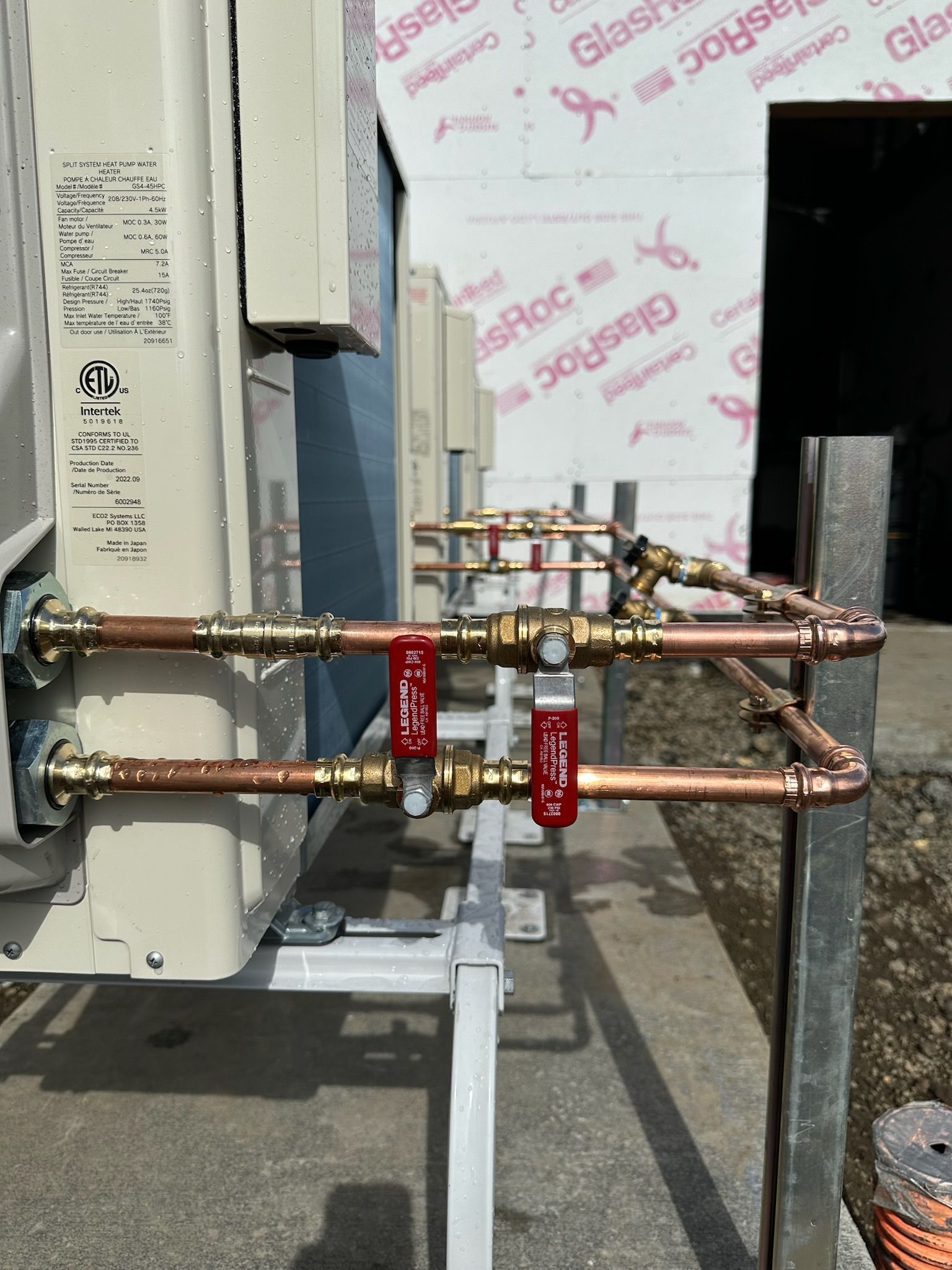 A row of copper pipes are connected to a building