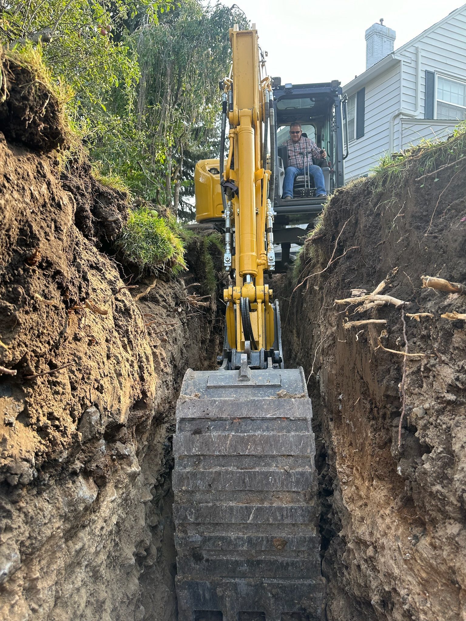 A yellow excavator is digging a hole in the ground