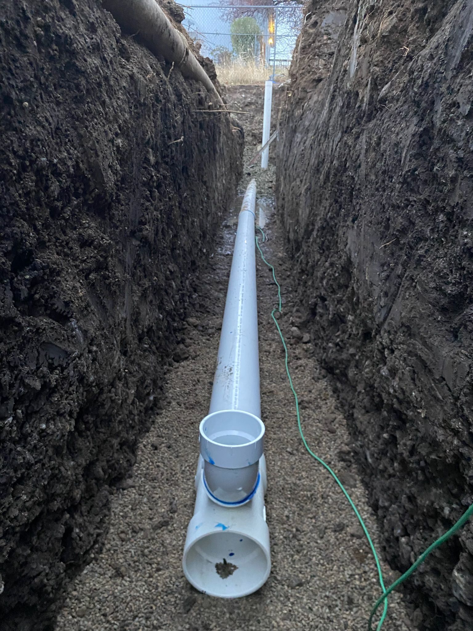 A drain pipe is being installed in a trench
