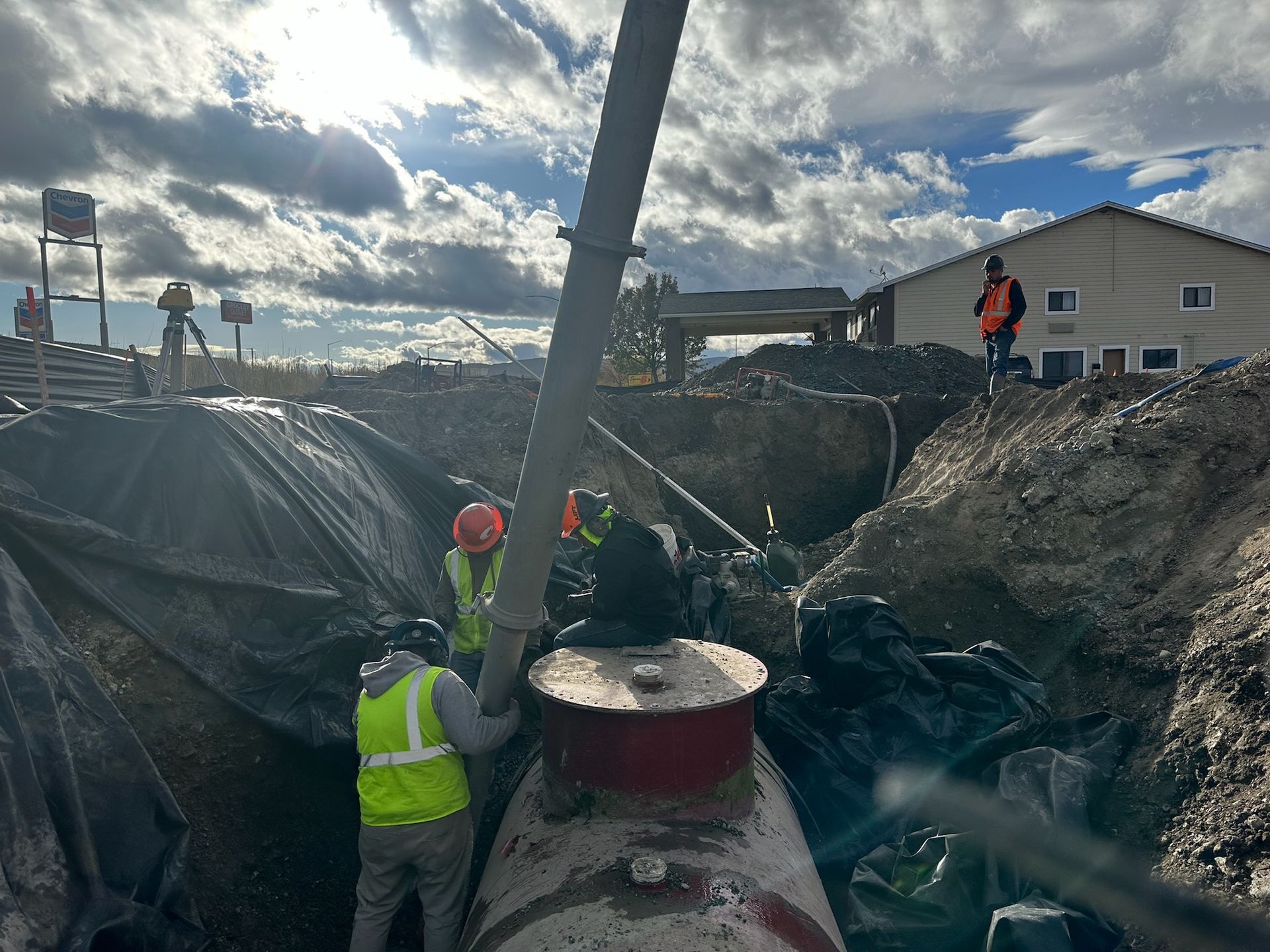 A group of construction workers are working on a large tank