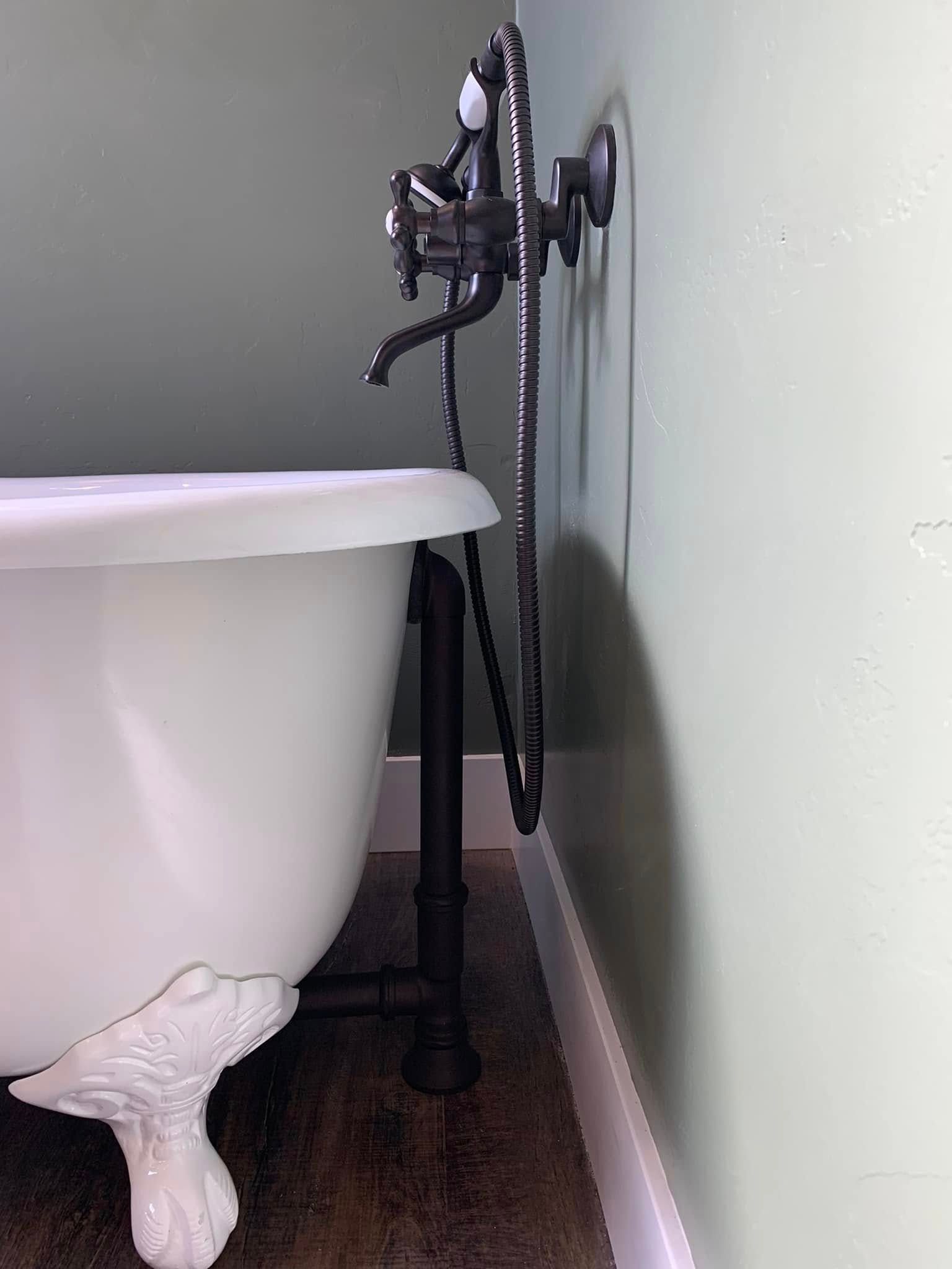 A white bathtub with a black faucet attached to it
