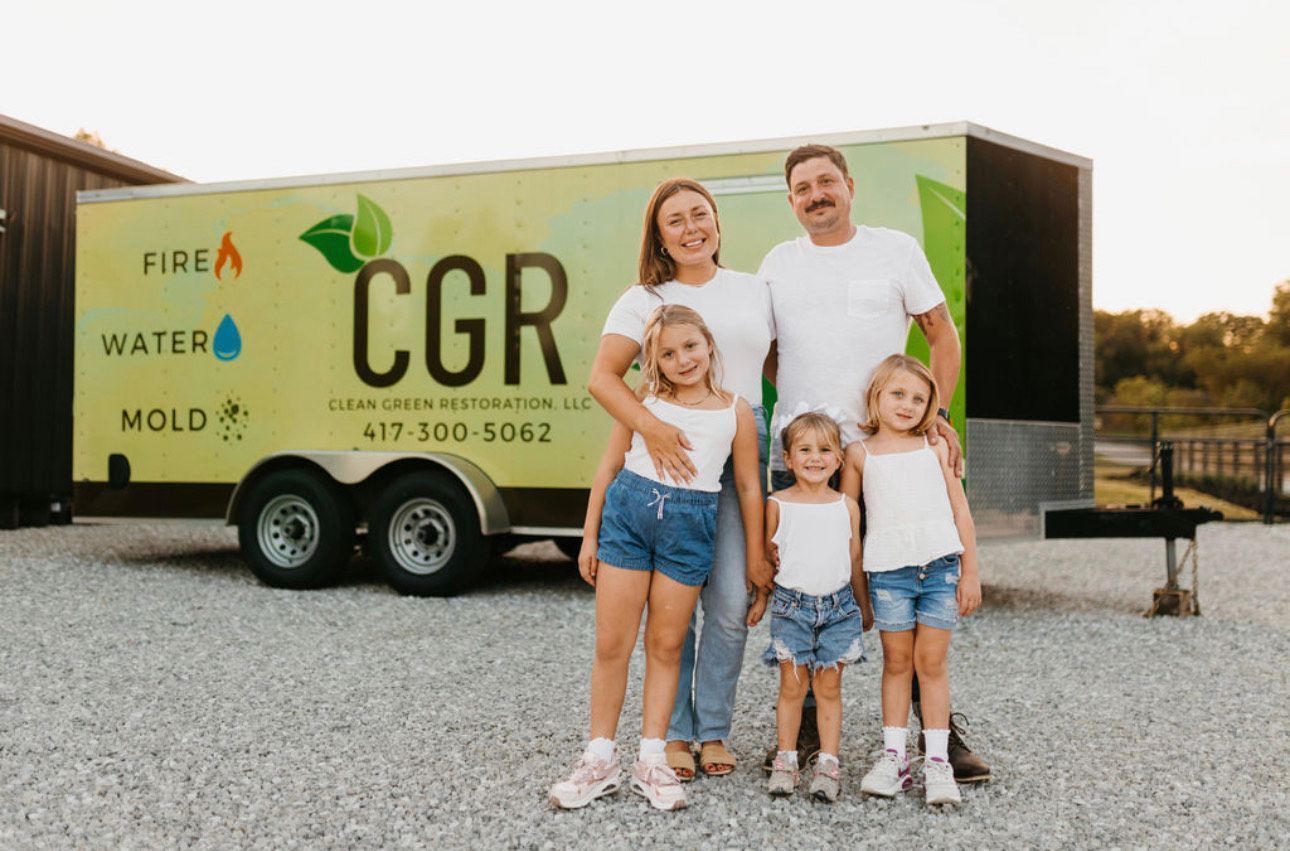 Family of five standing in front of a trailer with 