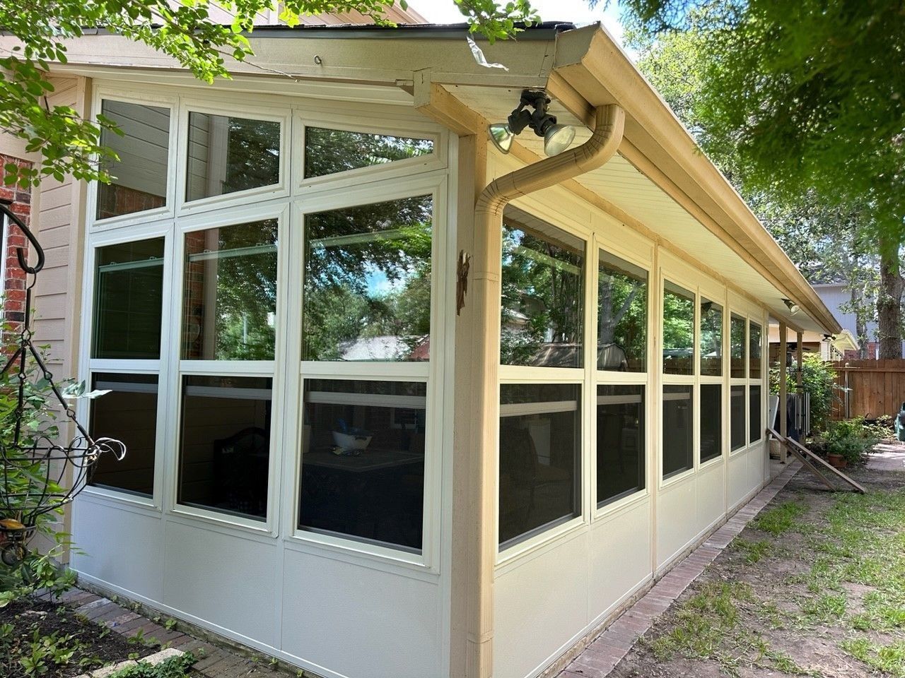 A house with a screened in porch and a lot of windows.