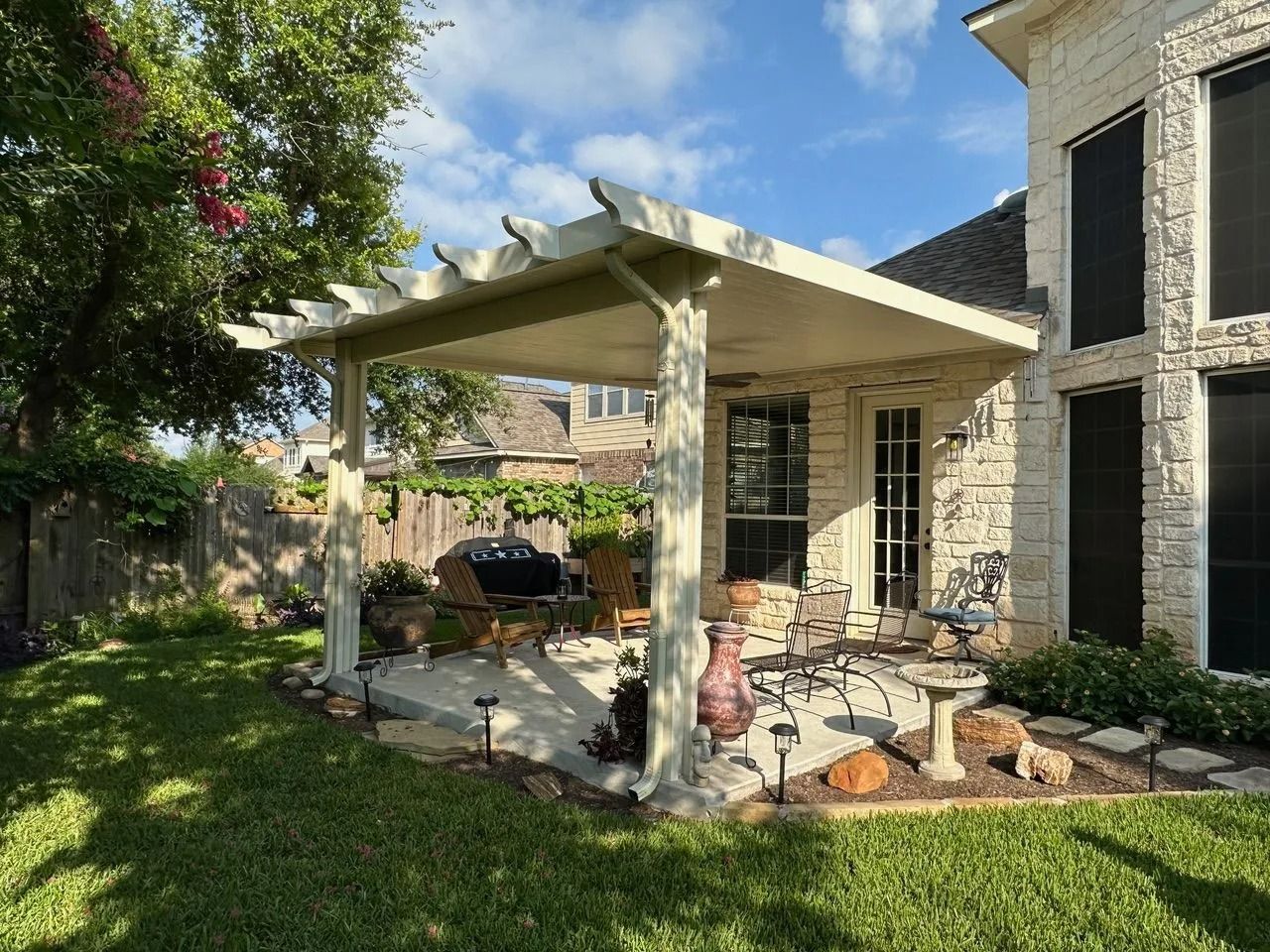 There is a pergola in the backyard of a house.
