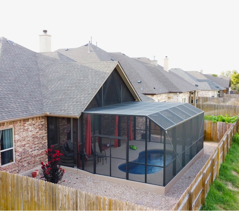 A screened in patio with a pool in the backyard