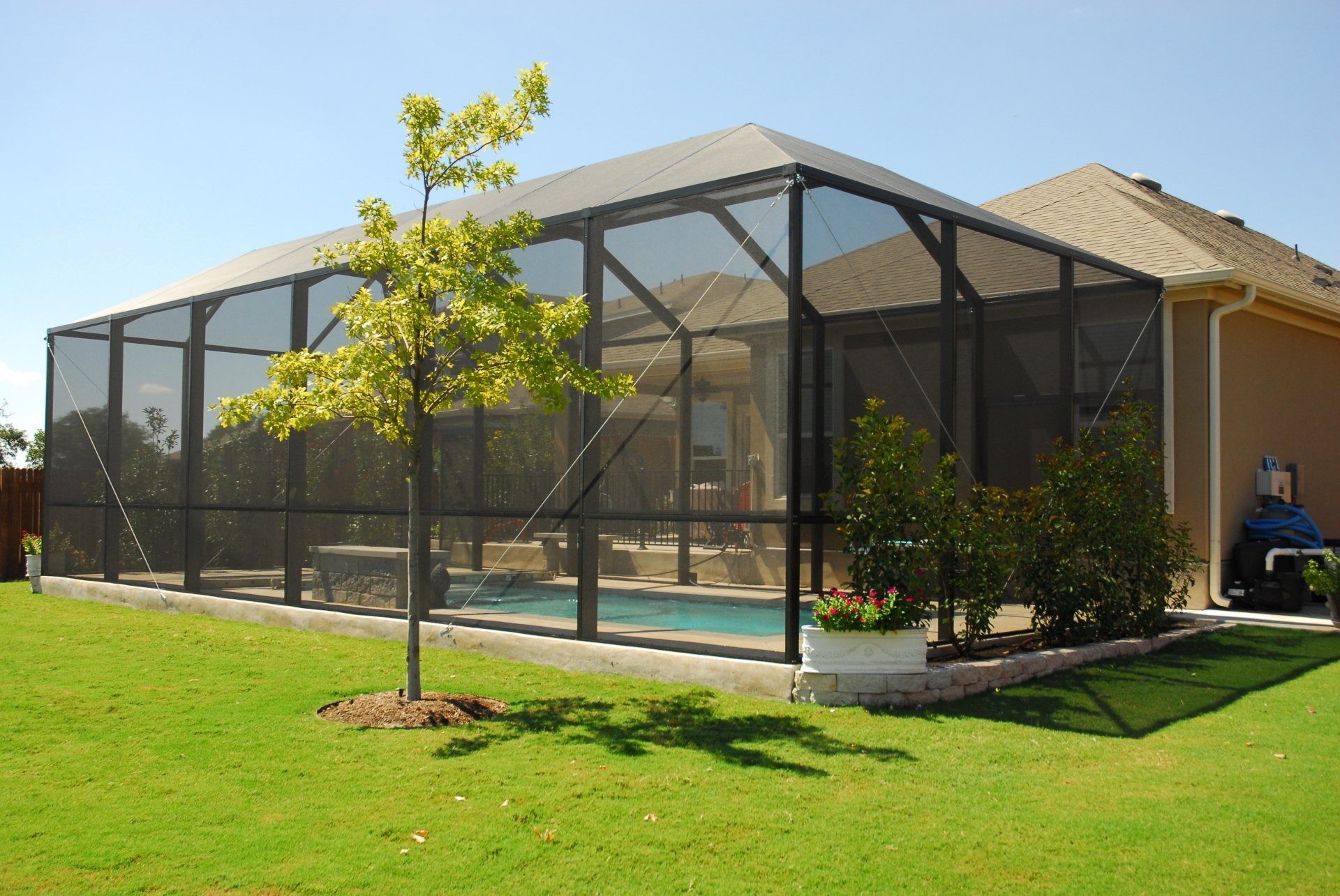 A house with a screened in swimming pool in the backyard