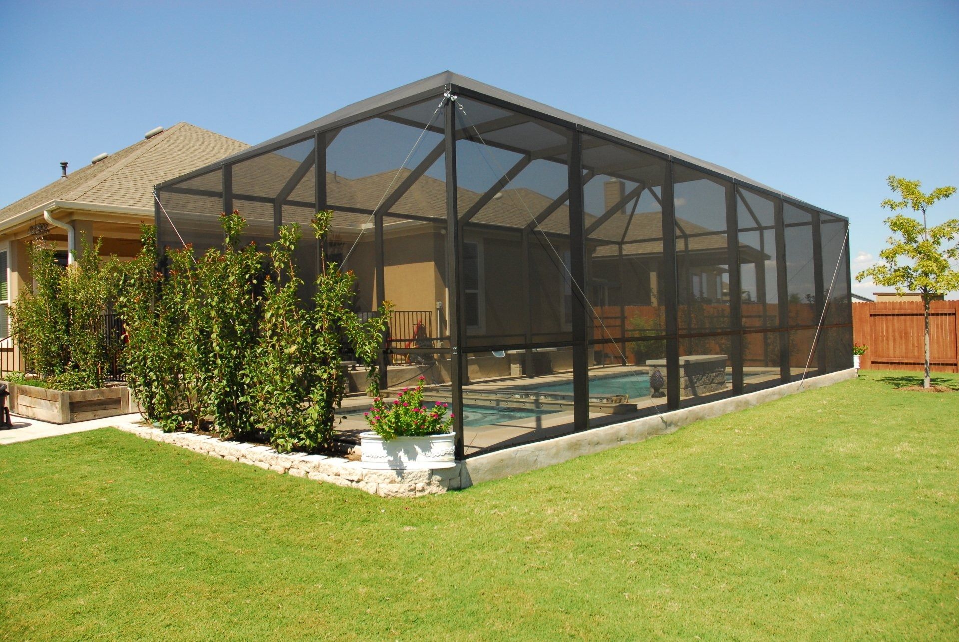 A screened in area with a pool in the backyard