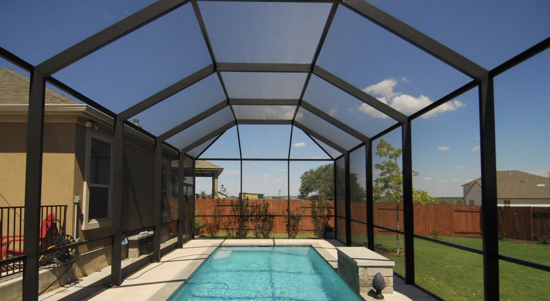 A screened in swimming pool with a clear roof