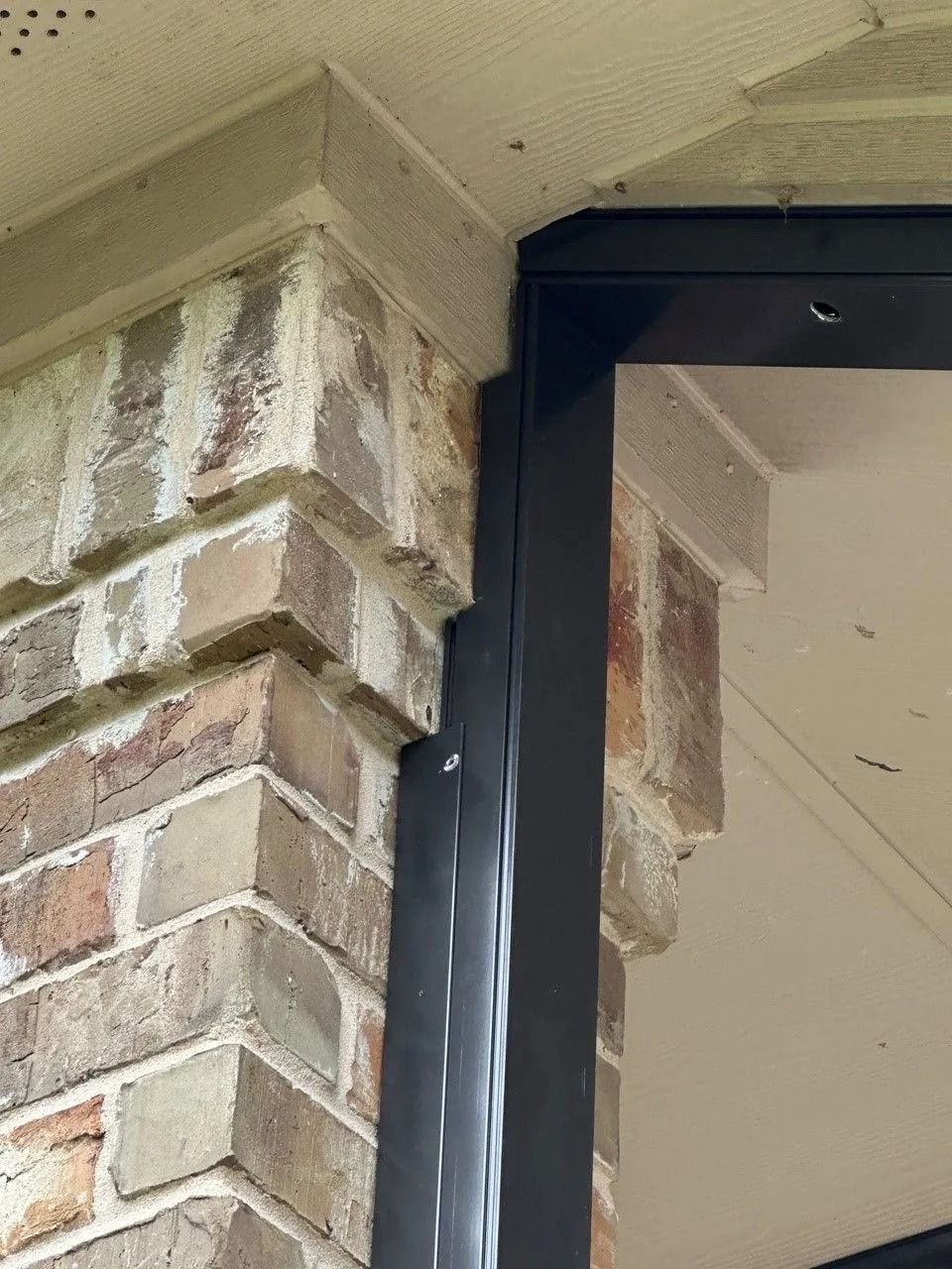 A close up of a brick wall with a black frame