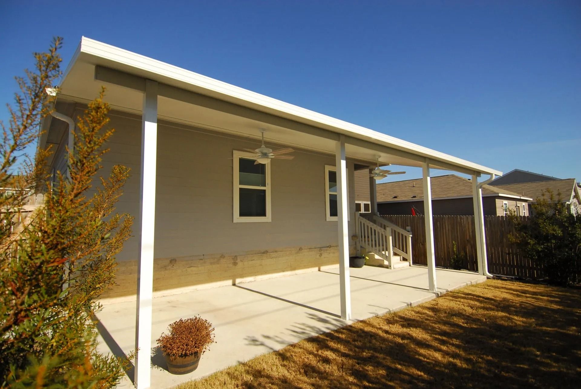 A house with a covered porch and a ceiling fan.