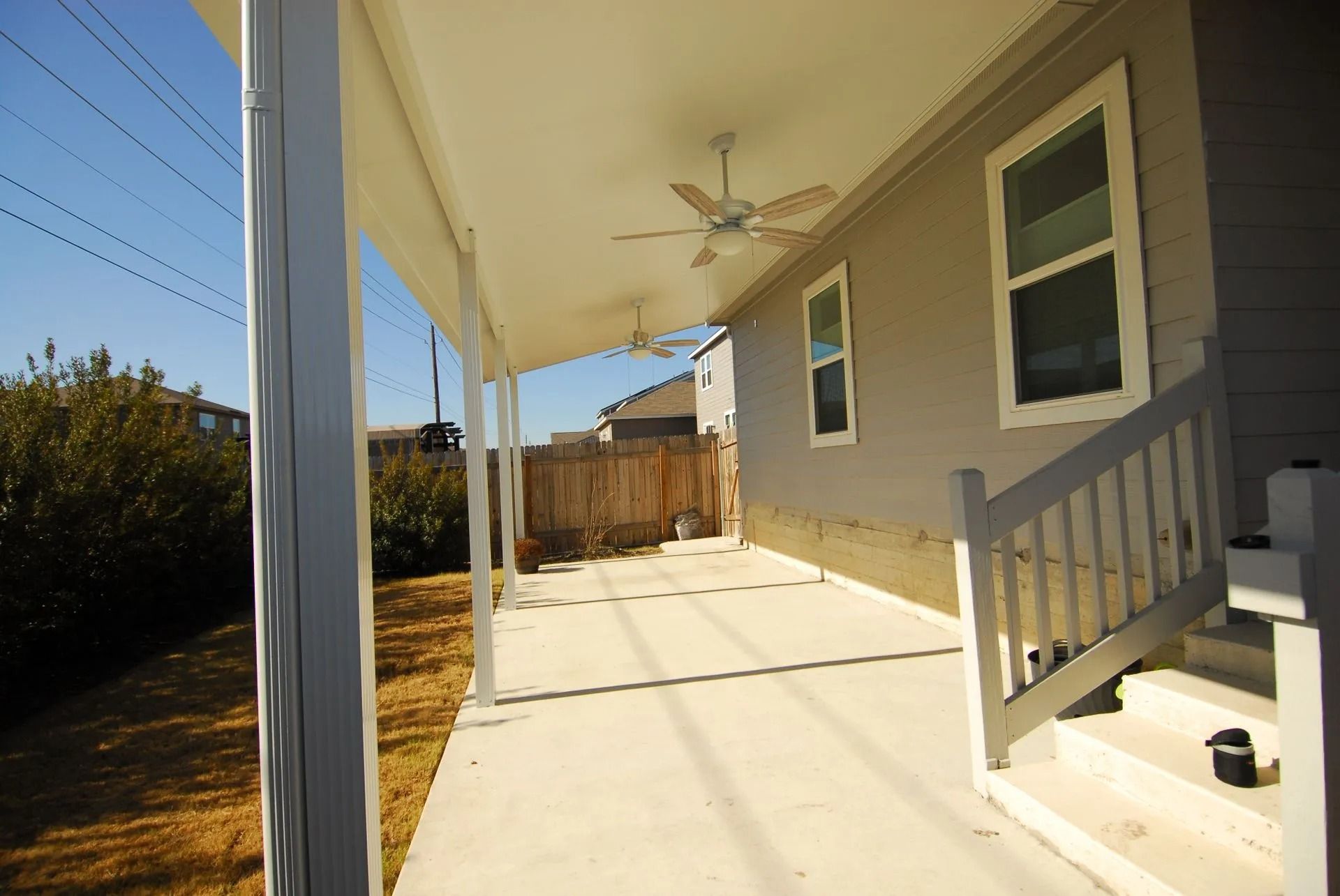 A porch with a ceiling fan and stairs leading up to it