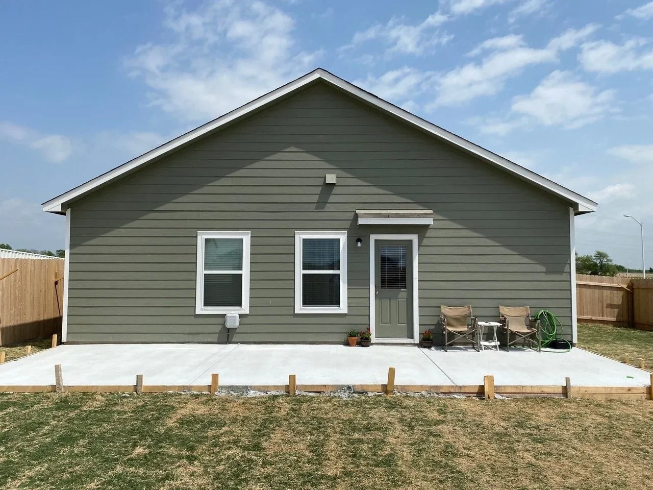 A small house with a concrete patio in front of it