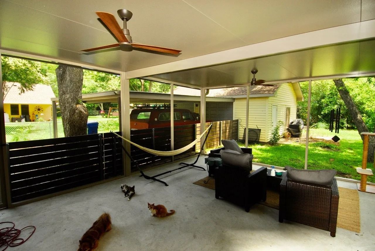 A screened in porch with a hammock and a ceiling fan