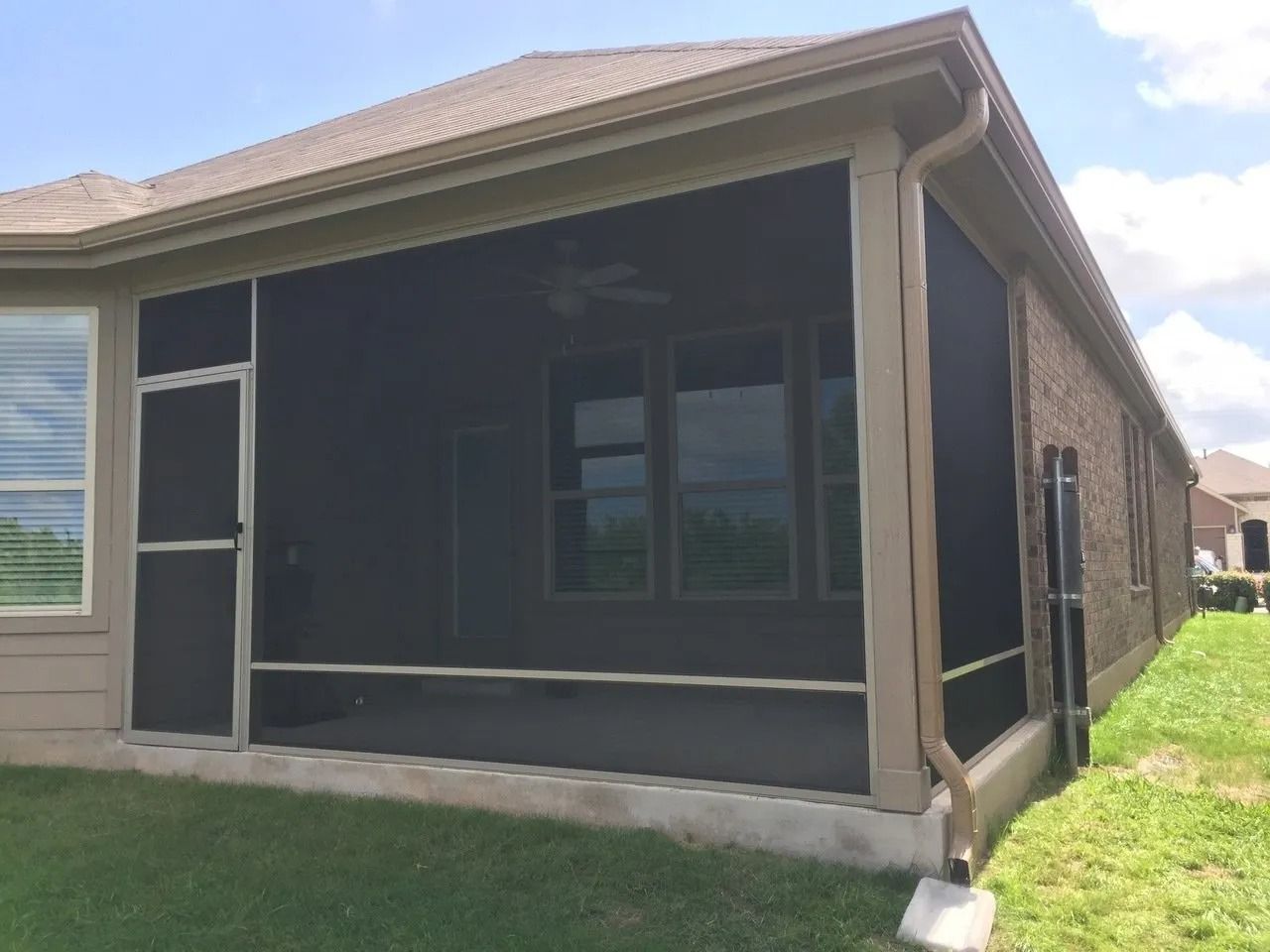 A screened in porch on the side of a house