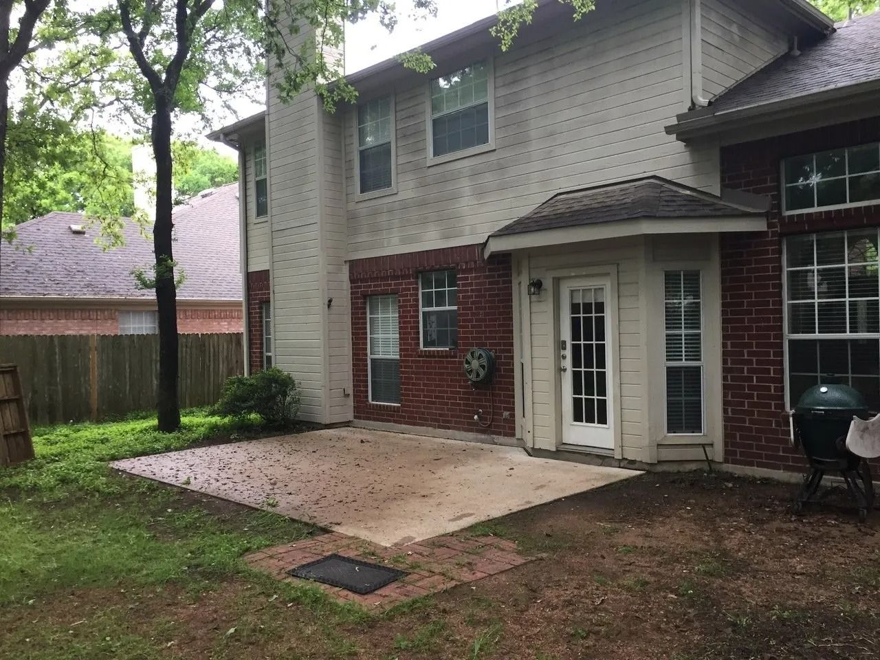 A large brick house with a patio in front of it.