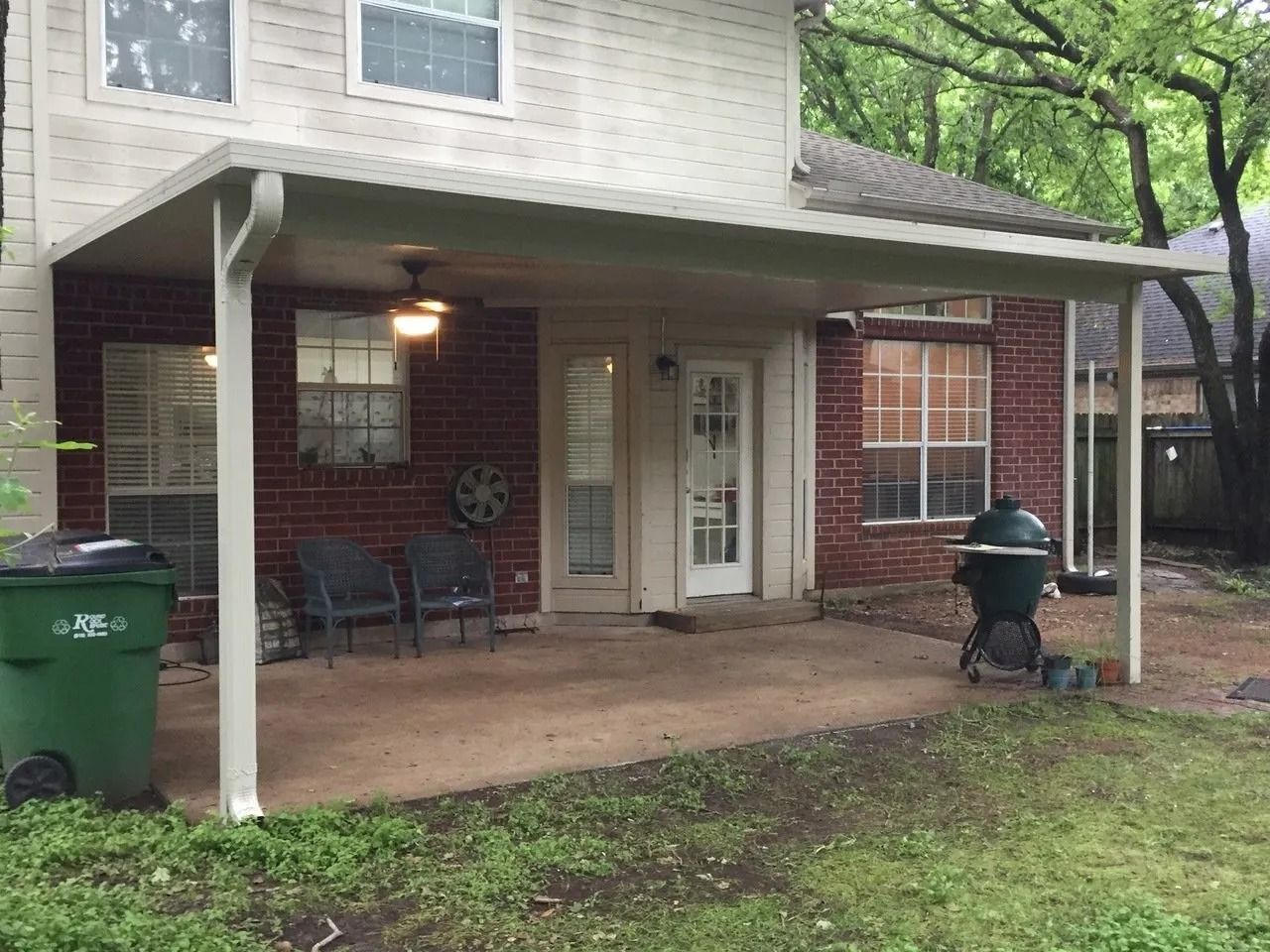 There is a covered patio in the backyard of a house.
