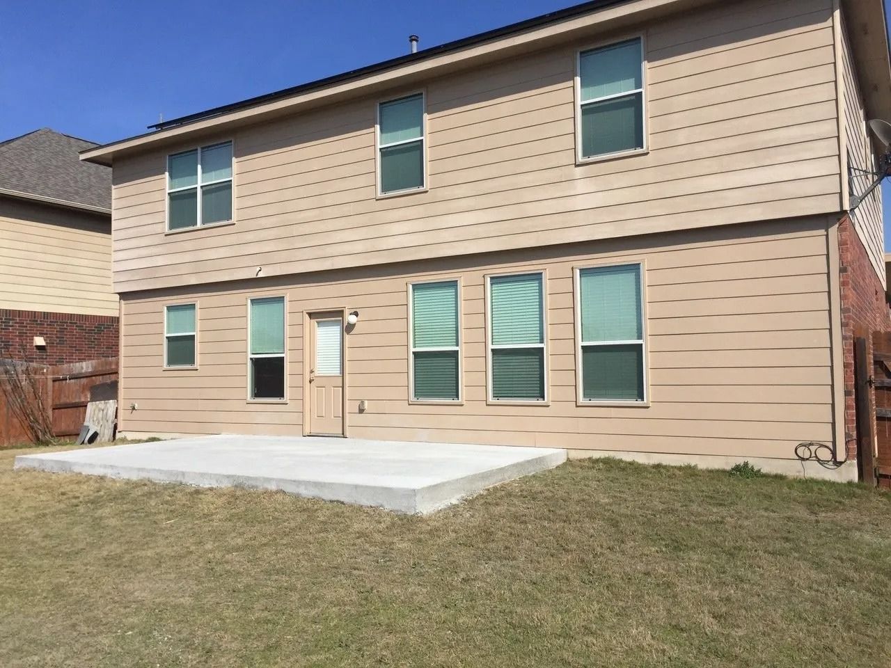 The back of a house with a concrete patio in front of it