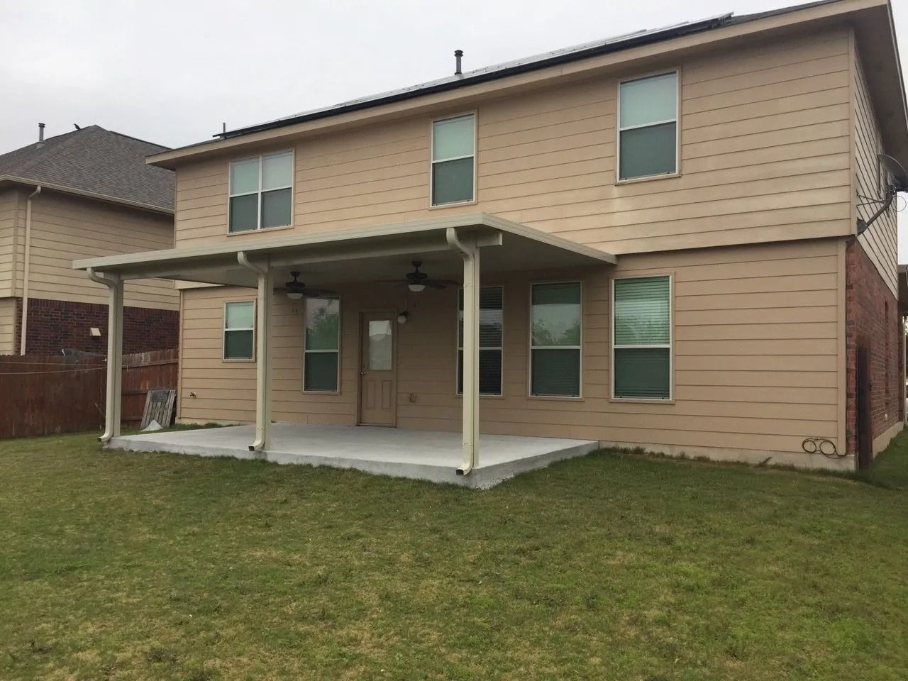 The back of a house with a patio and a covered porch.