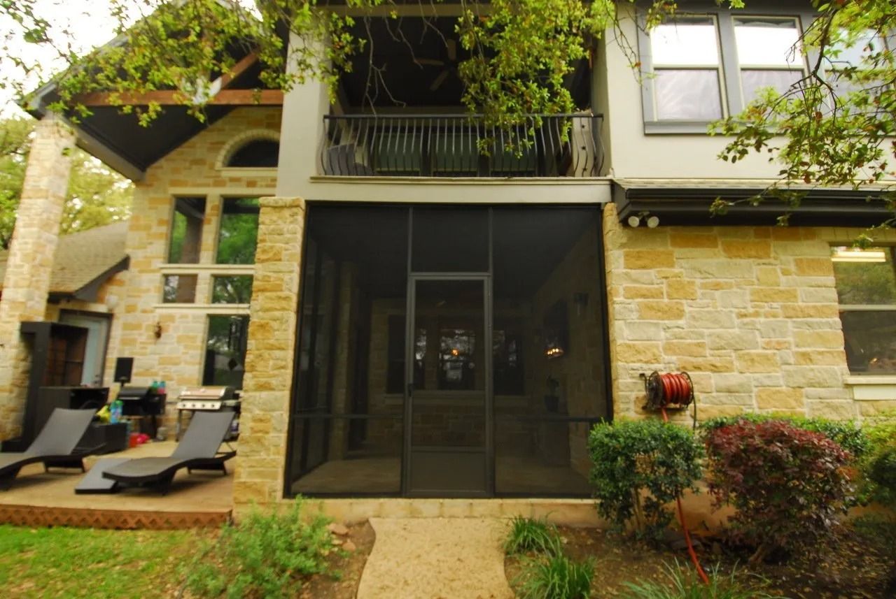 A house with a screened in porch and patio chairs
