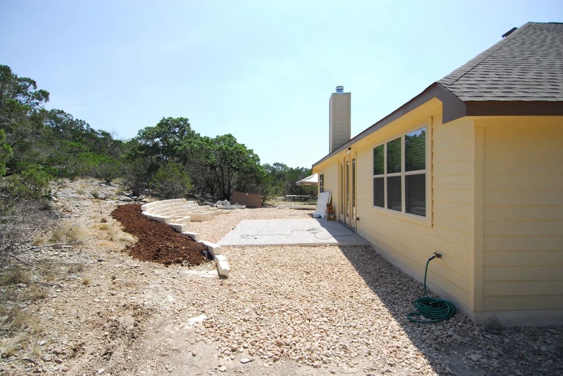 A yellow house with a chimney in the backyard