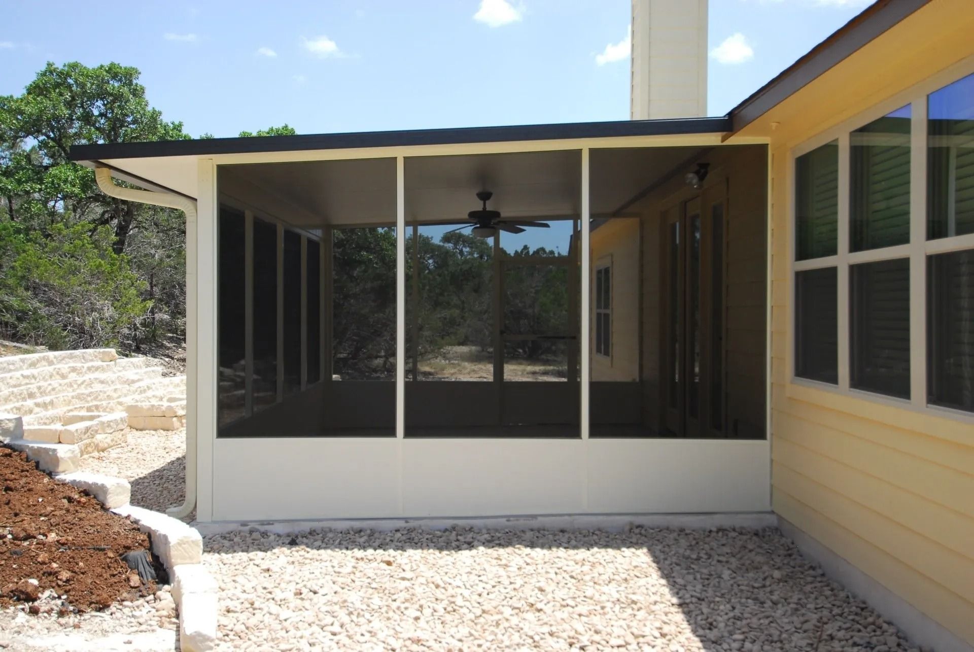 A screened in porch on the side of a house