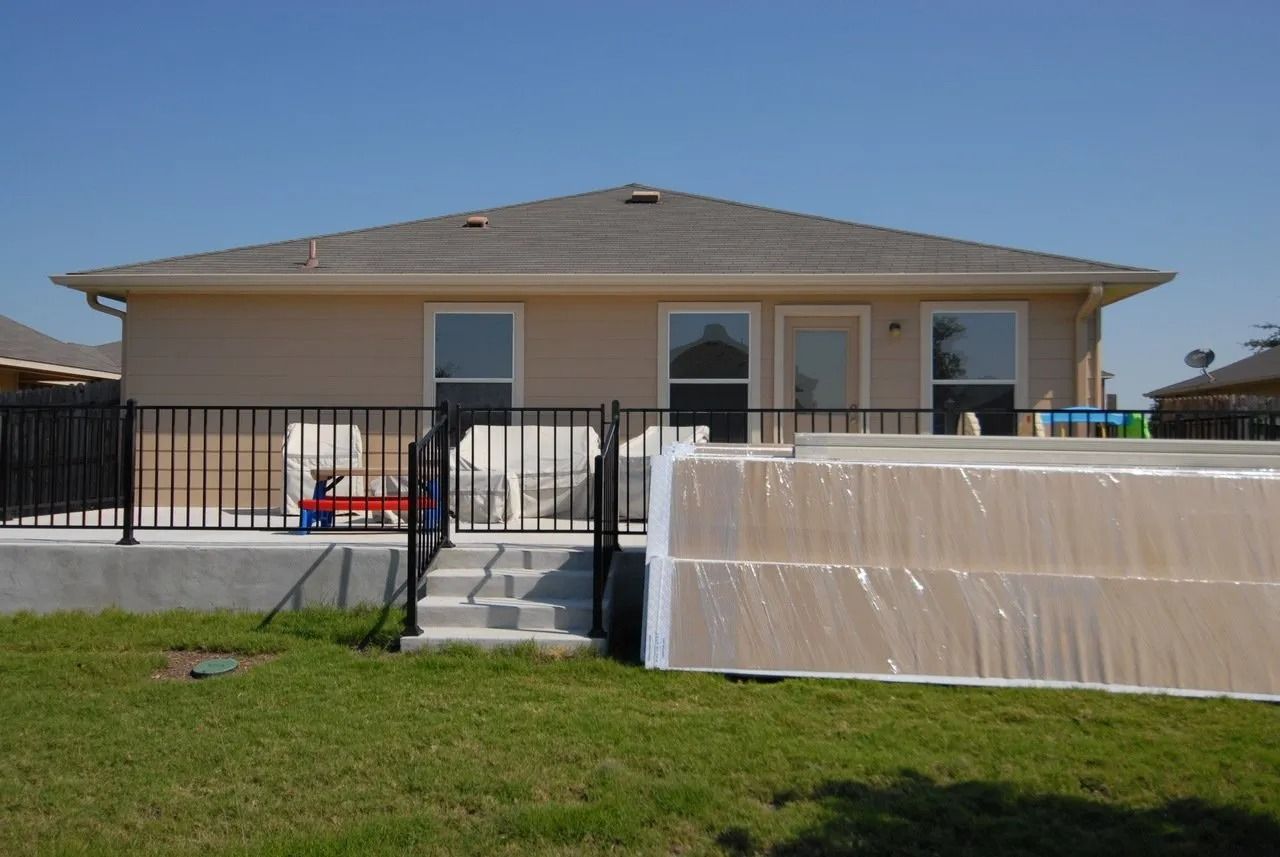 A house with a fence and a pool in the backyard