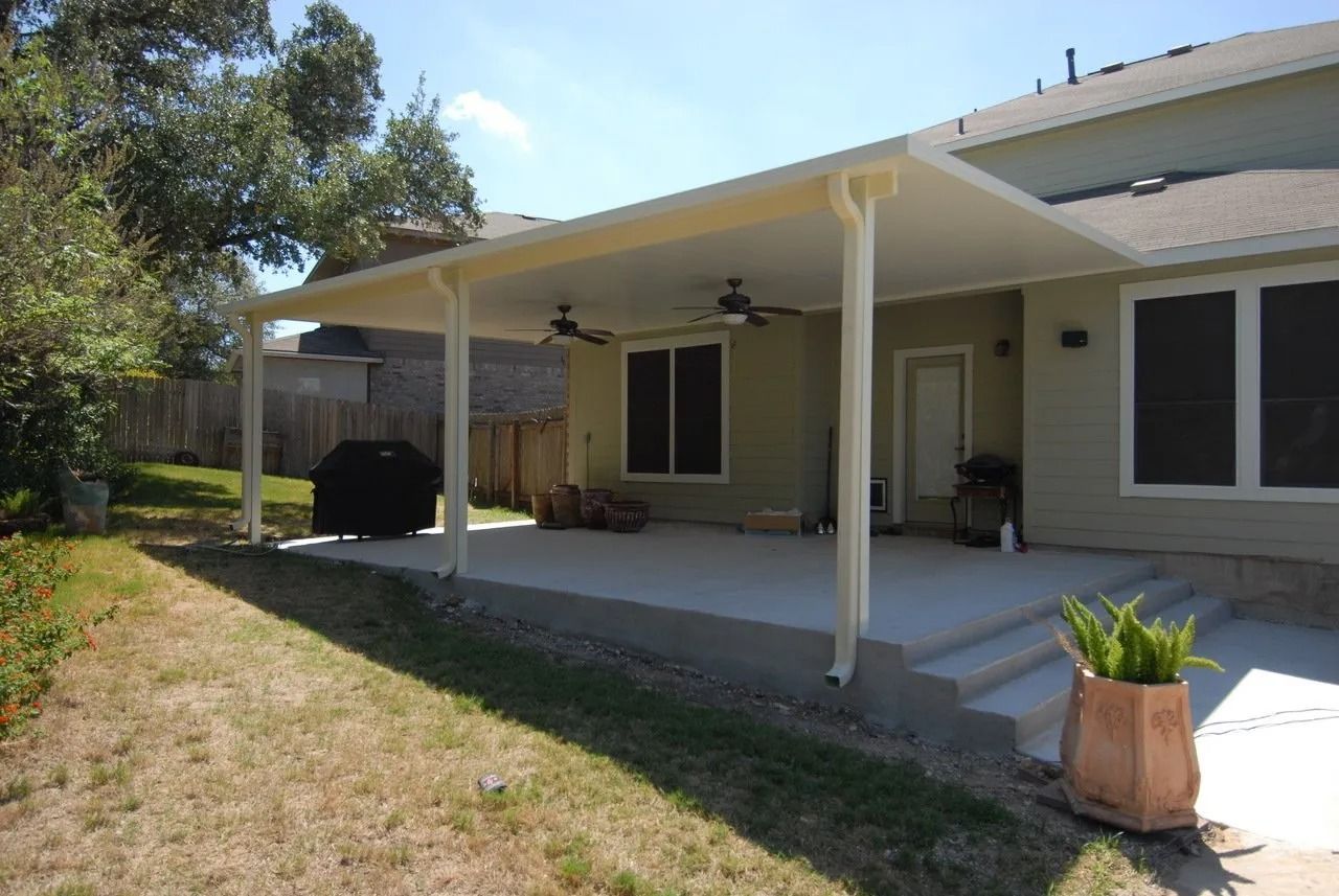 The back of a house with a patio and a ceiling fan.