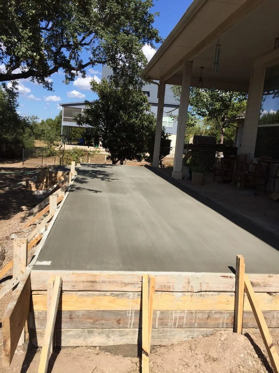 A concrete driveway is being built in front of a house
