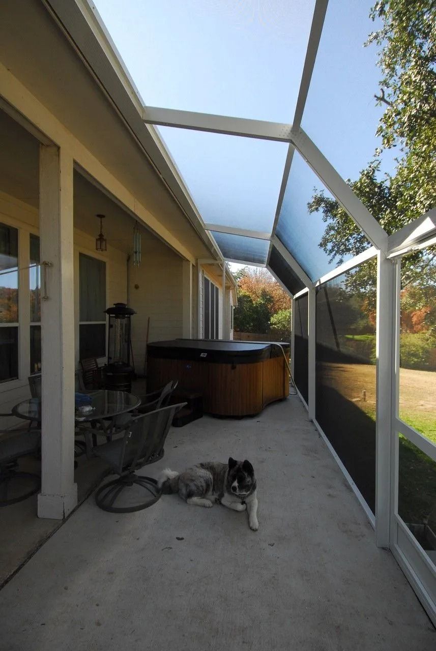 A dog laying on a patio next to a hot tub